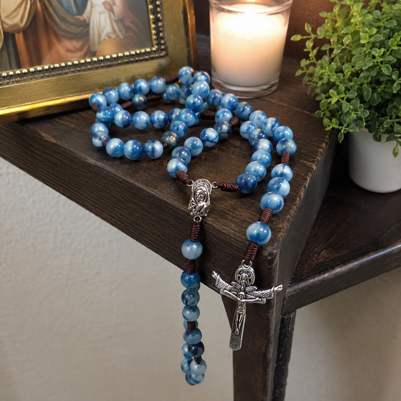 Blue Catholic rosary displayed in a home prayer corner