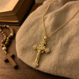 Gold cross pendant necklace on linen with prayer beads